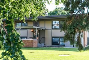Falcon Heights apartment for rent - A house with a green lawn and trees in front.