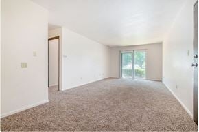 Bristol apartment for rent - A spacious room with a carpeted floor and a sliding glass door leading to a balcony.