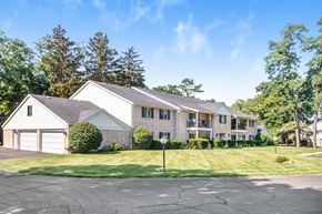 Elkhart apartment for rent - a white and gray house with a lawn and trees
