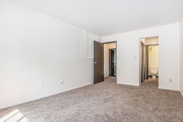 Bristol apartment for rent - a bedroom with white walls and carpet and a door to a bathroom