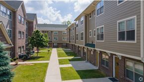 South Bend apartment for rent - A long, narrow walkway separates two rows of apartment buildings.