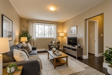 Kingston apartment for rent - A living room with a grey couch, a wooden coffee table, and a television on a cabinet.