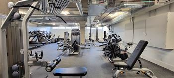 A gym with a variety of equipment including weights and cardio machines.