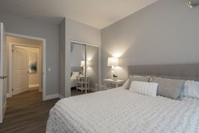 Kingston apartment for rent - A bedroom with a large bed and a nightstand with a lamp.