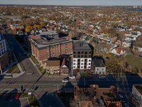 Kingston apartment for rent - A view of a city from above with buildings, cars, and trees.