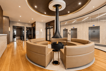 Kanata apartment for rent - A modern living room with a large circular table and a fireplace.