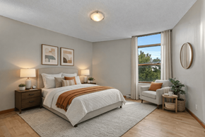 Kingston apartment for rent - A bedroom with a large bed and a window with curtains.