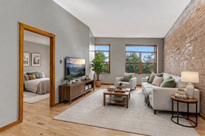 Kingston apartment for rent - A living room with a grey couch, a wooden coffee table, and a large mirror.