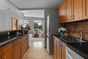 Kingston apartment for rent - A kitchen with wooden cabinets and a black countertop.