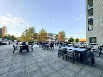 A patio with black furniture and a building in the background.