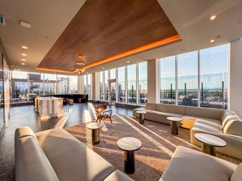 A large, modern lounge area with a variety of seating options and a view of the city.