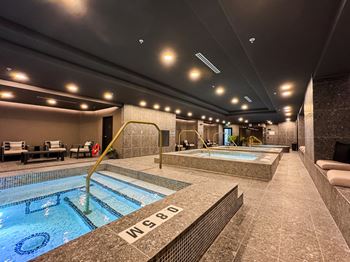 A large indoor swimming pool with a diving board.