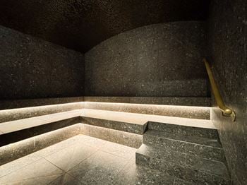 A staircase with a golden handrail leads up to a bright light.