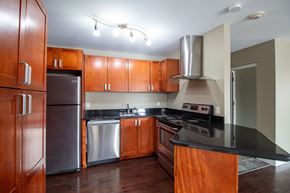 Kingston apartment for rent - A kitchen with wooden cabinets and a black countertop.