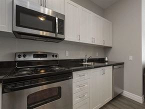 Kingston apartment for rent - a kitchen with stainless steel appliances and white cabinets