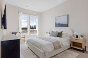 Kanata apartment for rent - A bedroom with a large bed and a flat screen TV mounted on the wall at The Woods at 180 Kanata Avenue Apartments, Kanata, Ontario