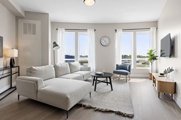 Kanata apartment for rent - A living room with a grey sofa and a wooden coffee table.