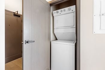 A white dishwasher and oven are built into a cabinet in a kitchen