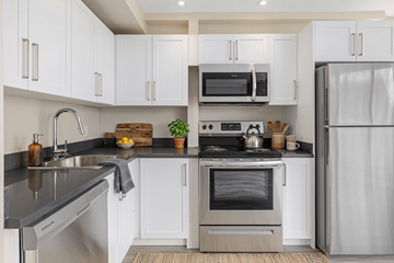 Kingston apartment for rent - A modern kitchen with white cabinets and stainless steel appliances.