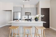 Kanata apartment for rent - A kitchen with a white counter and bar stools aat The Woods at 180 Kanata Avenue Apartments, Ontario, K2T 0T4