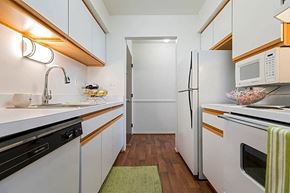 Clinton Township apartment for rent - a kitchen with white cabinets and a white refrigerator