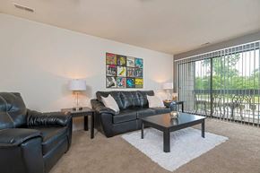 Clinton Township apartment for rent - a living room with leather furniture and a sliding glass door