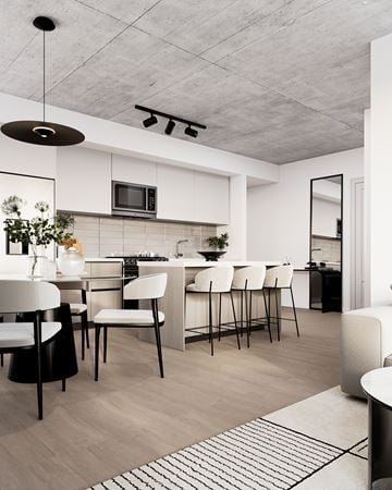 Laval apartment for rent - A modern kitchen with white cabinets and a black and white rug on the floor.