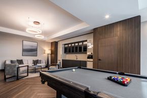 Ottawa apartment for rent - A pool table is in the middle of a room with a couch and a chair.