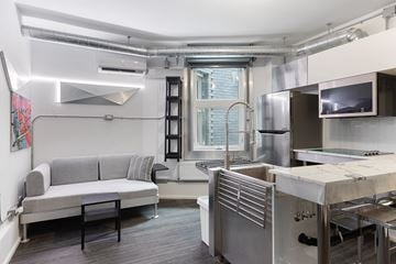 Ottawa apartment for rent - A kitchen with a grey couch and stainless steel appliances.