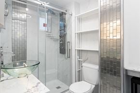 Ottawa apartment for rent - A white toilet sits in a bathroom with a glass bowl on the counter.