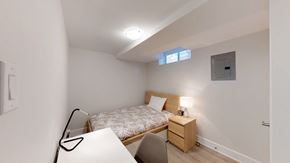 Ottawa apartment for rent - a bedroom with a bed and a desk and a window