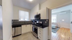 Ottawa apartment for rent - a kitchen with black counter tops and a stove and a microwave