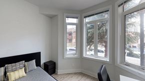 Ottawa apartment for rent - a bedroom with a bed and three large windows