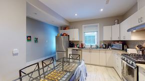 Ottawa apartment for rent - a kitchen with white cabinets and stainless steel appliances and a glass table