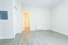 Ottawa apartment for rent - an empty living room with wood floors and white walls