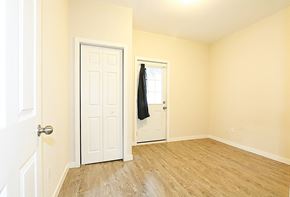 Ottawa apartment for rent - an empty bedroom with a white door and wood floors