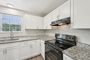 Jacksonville apartment for rent - A kitchen with white cabinets and granite countertops.