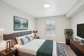 Jacksonville apartment for rent - A bedroom with a bed, nightstand, and a painting on the wall.