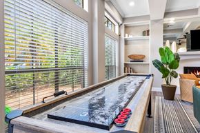 Tampa apartment for rent - A pool table with red balls is in the foreground of a room with a window covered in blinds.