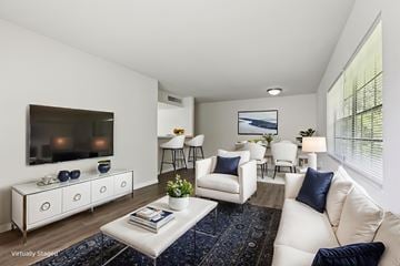 Tampa apartment for rent - A living room with white furniture and a flat screen TV mounted on the wall.