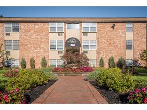 Warminster apartment for rent - A brick building with a garden in front.