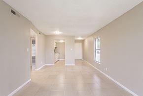 Tampa apartment for rent - A spacious room with tiled flooring and white walls.