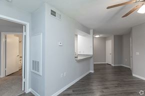 Tampa apartment for rent - A spacious room with a ceiling fan and a doorway leading to another room.