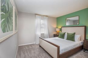 Lakeland apartment for rent - A bedroom with a large bed and a green wall.