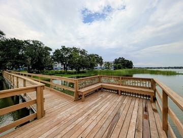 Lakeland apartment for rent - A wooden deck overlooks a body of water with a green landscape in the background.