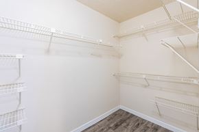 Tampa apartment for rent - a spacious walk in closet with white walls and shelves and mirrored closet doors  at Fisherman's Landing Apartment Homes, Tampa, Florida