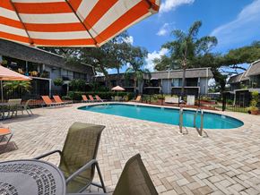 Tampa apartment for rent - a swimming pool with chairs and an umbrella at a hotel at Greenwich Commons Apartment Homes, Florida