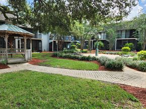 Tampa apartment for rent - a gazebo in the middle of a yard in front of a building at Greenwich Commons Apartment Homes, Tampa, FL, 33613