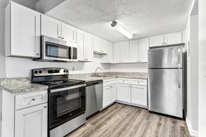 Tampa apartment for rent - a kitchen with stainless steel appliances and white cabinets at Greenwich Commons Apartment Homes, Tampa