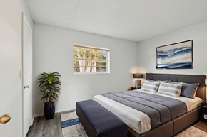 Eustis apartment for rent - A bedroom with a large bed and a potted plant.